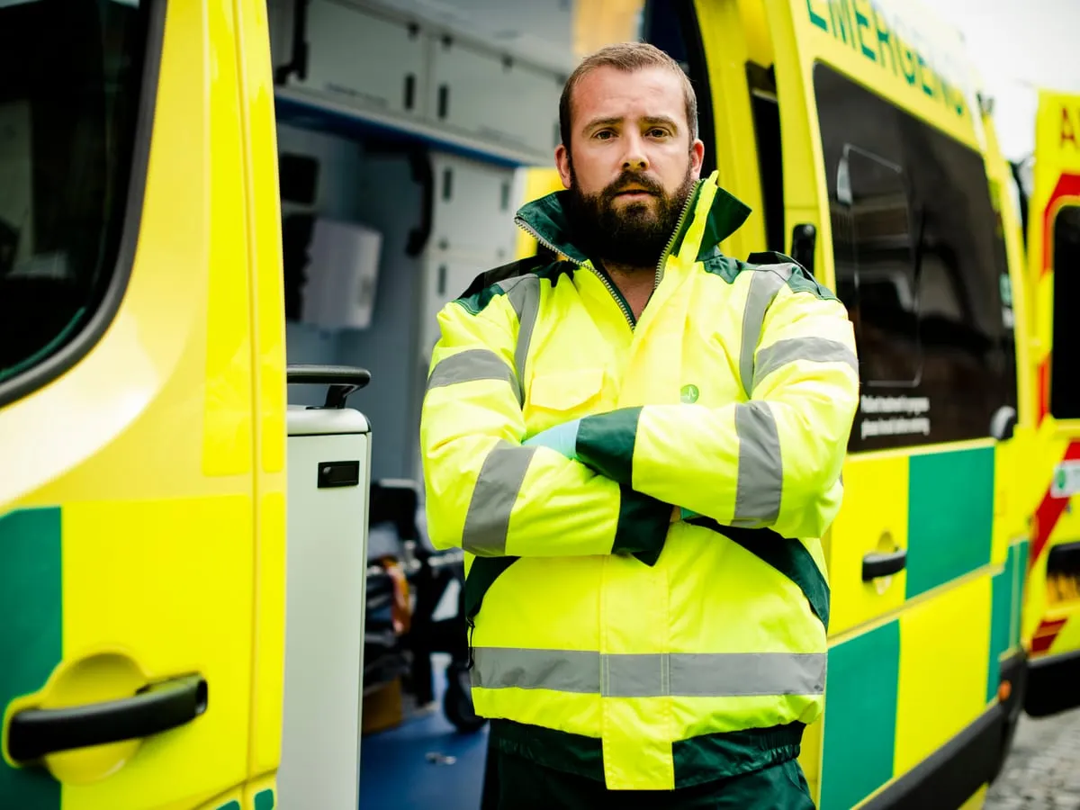 Paramedic C1 training with an ambulance driver beside an emergency ambulance
